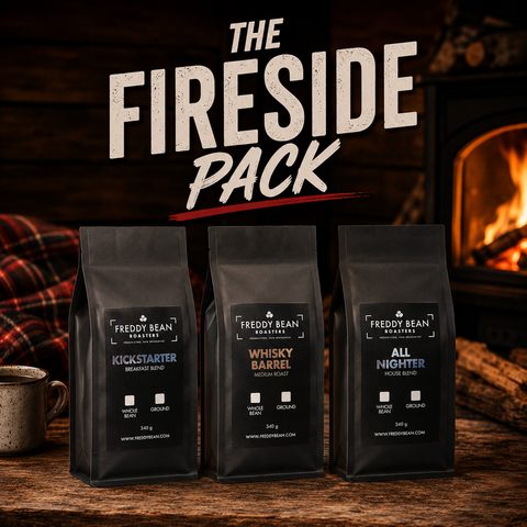 Three black coffee bags labeled 'Freddy Bean' with a fireplace in the background.